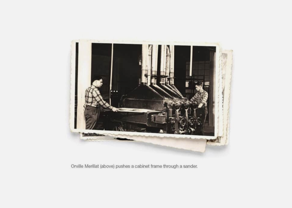Orville Merillat pushes a cabinet frame through a sander